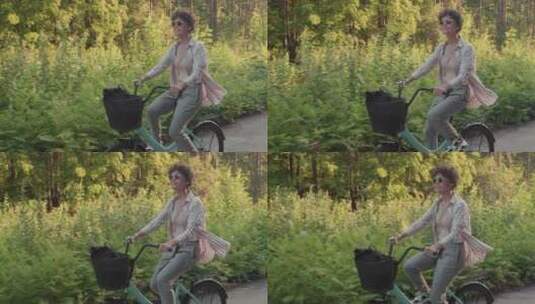 在森林小径上骑自行车的女人高清在线视频素材下载