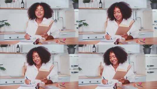 年轻的非裔美国妇女坐在厨房里在工作簿上做笔记高清在线视频素材下载