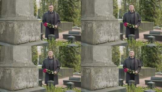 男人拿着鲜花站在墓碑前高清在线视频素材下载