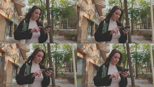 年轻女子走在街上玩手机高清在线视频素材下载