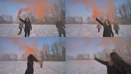 女孩朋友们带着彩色烟雾跑过冬天的田野高清在线视频素材下载