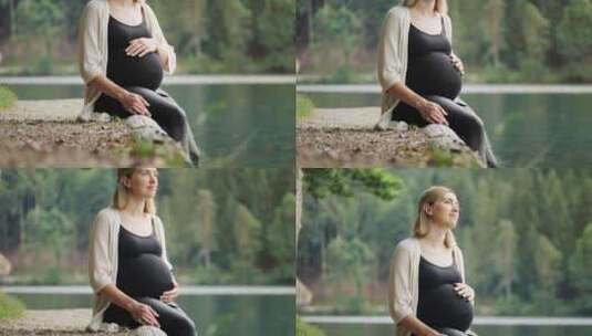 孕妇坐在山湖附近轻轻抚摸肚子高清在线视频素材下载
