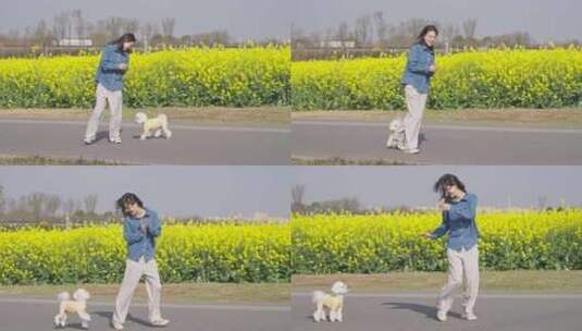 美女和小狗在春天的田野玩耍阳光油菜花海高清在线视频素材下载