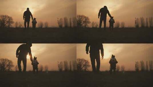 父亲和小儿子在草地上踢球的剪影高清在线视频素材下载