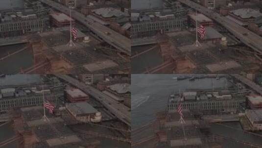 美国航空公司：纽约布鲁克林大桥上空有美国国旗和雾蒙蒙的曼哈顿上空的特写圆圈飞行高清在线视频素材下载