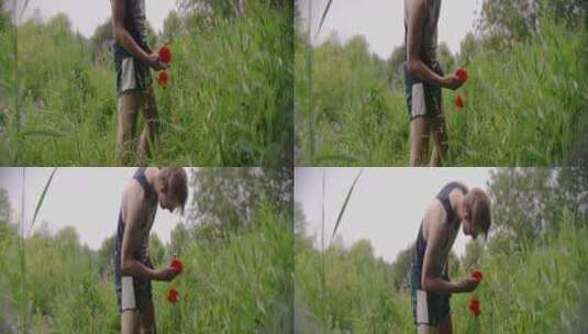 男子在公园里闻着花朵的气味高清在线视频素材下载