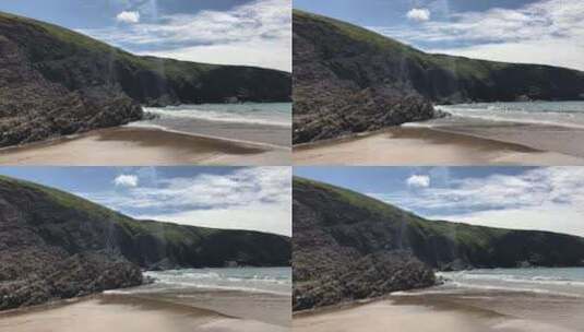 威尔士的沙滩在卡迪根湾崎岖的岩石海岸线前高清在线视频素材下载