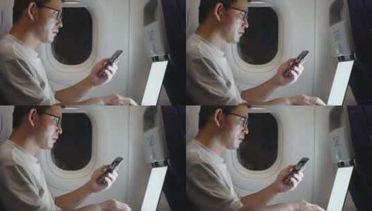 男子在飞机上使用笔记本电脑和手机高清在线视频素材下载
