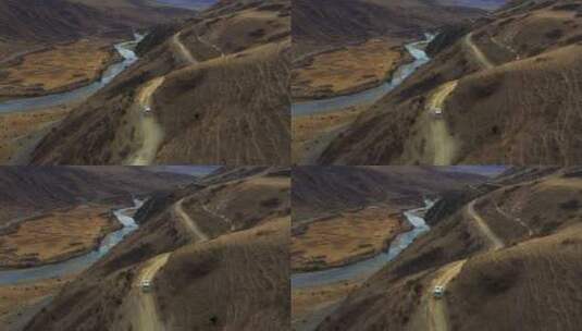 航拍越野车行驶在高原草甸半山腰的公路上高清在线视频素材下载