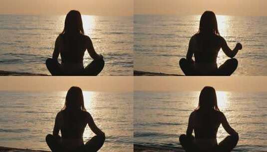 一名瑜伽女子坐在海看日落高清在线视频素材下载