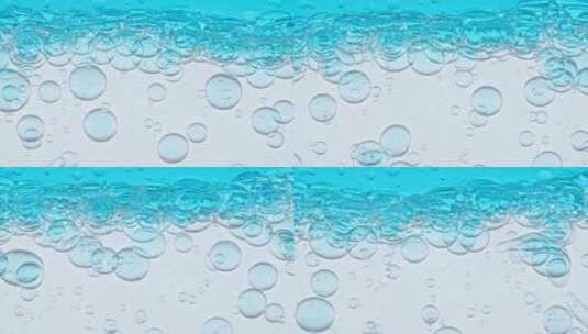 浅蓝色背景下清水中不同大小透明气泡的微距高清在线视频素材下载