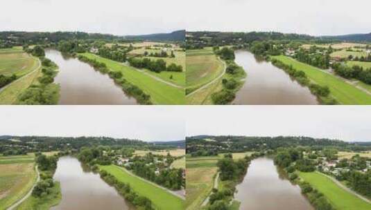 晴天，无人机拍摄了一条大河流经一个有村庄的农村地区高清在线视频素材下载