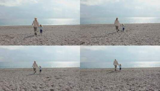 海滩上的秋天母亲和女儿跑向大海或海洋高清在线视频素材下载