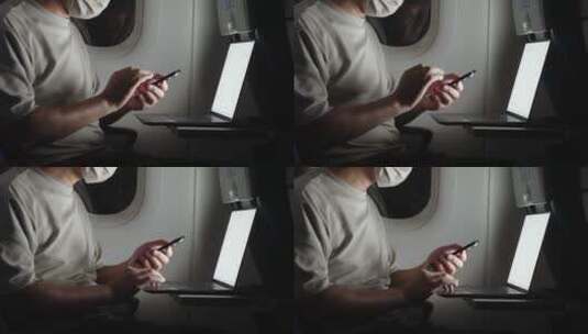 疫情期间男子在飞机上使用手机和笔记本电脑高清在线视频素材下载