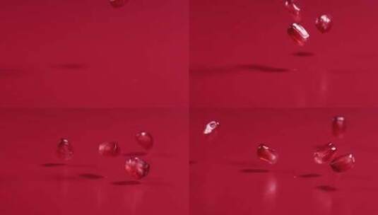 红石榴籽在红色背景中从空中落下，4k慢镜头高清在线视频素材下载
