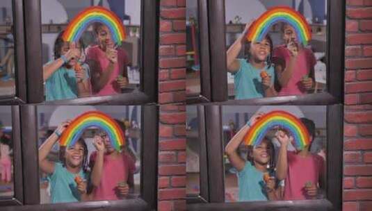 快乐的女孩在窗户上画明亮的彩虹高清在线视频素材下载