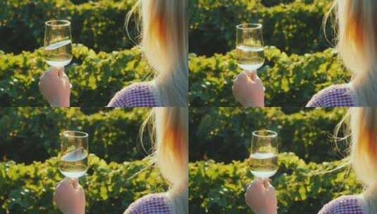 女人在葡萄园里晃动葡萄酒高清在线视频素材下载