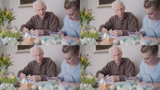 快乐祖父和孙女在家写复活节贺卡高清在线视频素材下载