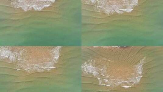 航拍俯瞰山东威海国际海水浴场沙滩上的海浪高清在线视频素材下载