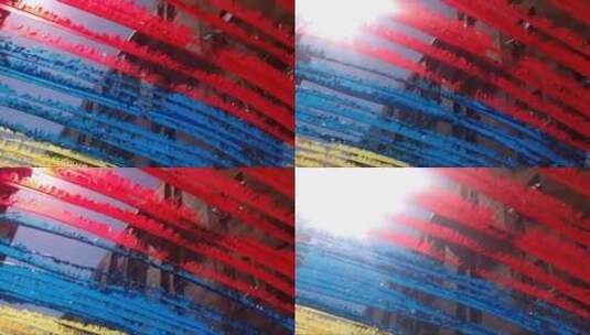 阳光下的红蓝色的绳子被风吹扬高清在线视频素材下载