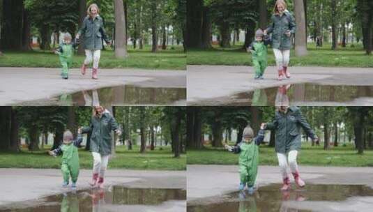 母亲带着穿着雨靴的孩子在公园水坑玩耍高清在线视频素材下载