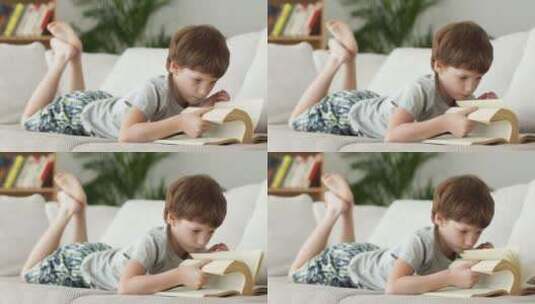 小男孩在沙发上看书高清在线视频素材下载