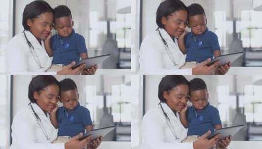 医生在诊所向婴儿患者展示平板电脑高清在线视频素材下载