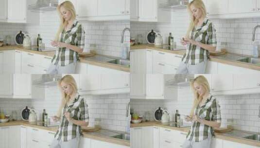 女人在厨房里玩手机高清在线视频素材下载