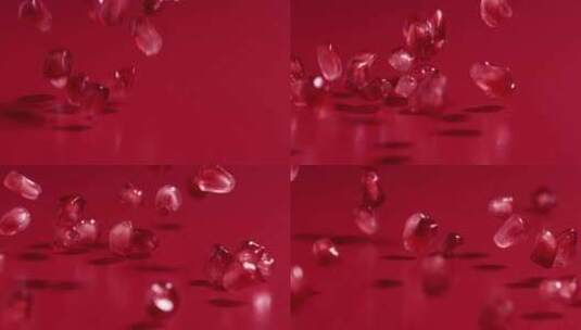 红石榴籽在红色背景中从空中落下，4k慢镜头高清在线视频素材下载
