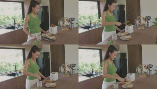 女人在明亮的现代厨房里做吐司高清在线视频素材下载