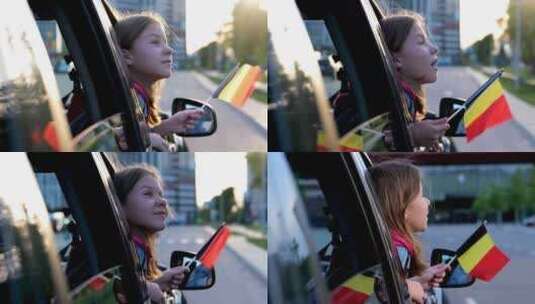 微笑的小女孩举着比利时国旗，坐在前面看着高清在线视频素材下载
