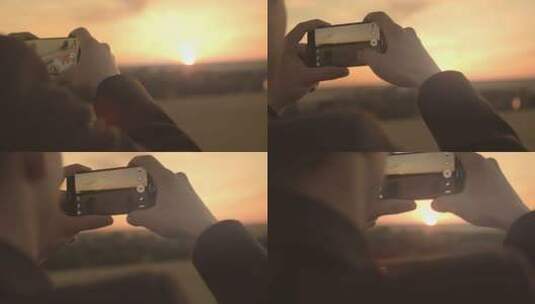 夕阳下男人拿着手机拍照日落风景高清在线视频素材下载