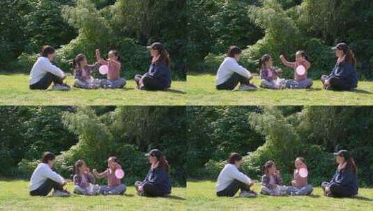 秋天午后围坐在草坪上玩耍的母亲和女孩高清在线视频素材下载