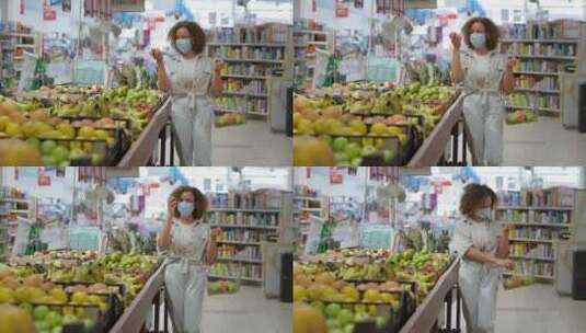 带着口罩的女孩在超市里挑选水果高清在线视频素材下载