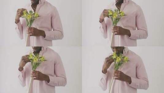 男模特闻黄色花朵的特写镜头高清在线视频素材下载