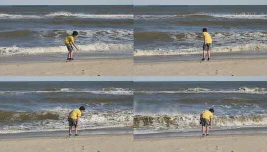 男孩用树枝在海滩上画画高清在线视频素材下载