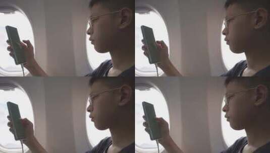 男孩在飞机上使用手机高清在线视频素材下载