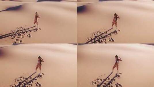 比基尼女人站在炎热的沙漠中的无人机高清在线视频素材下载
