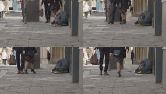 行人经过街上无家可归者物品的镜头高清在线视频素材下载