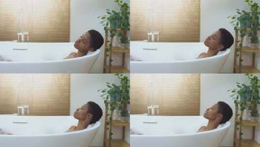微笑的非洲迷人女人戴着耳机在浴室的泡沫浴缸里放松和跳舞高清在线视频素材下载