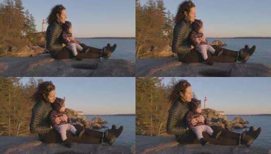 日落背景下，母亲和小男孩坐在风景优美的海高清在线视频素材下载