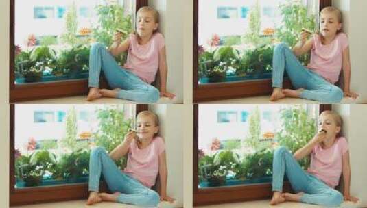 坐在窗台上吃黄瓜的女孩高清在线视频素材下载