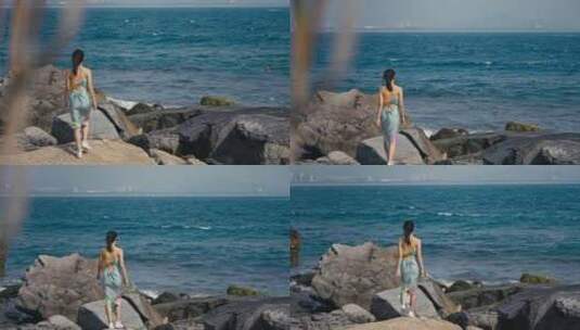 美女走在海边的礁石上高清在线视频素材下载