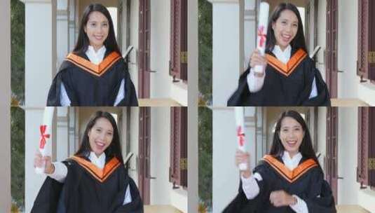 女生穿着毕业礼服开心的举起文凭高清在线视频素材下载