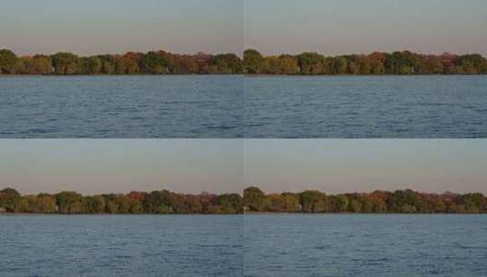 夕阳下的西湖水面与杨公堤秋色高清在线视频素材下载