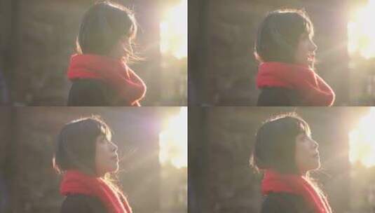 一个戴红色围巾的女人站在阳光下看远方风景高清在线视频素材下载