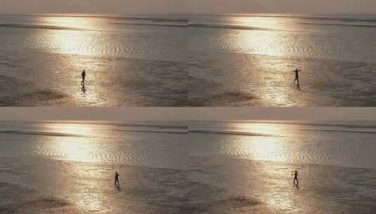 一个人行走在夕阳照耀下的沙滩上高清在线视频素材下载