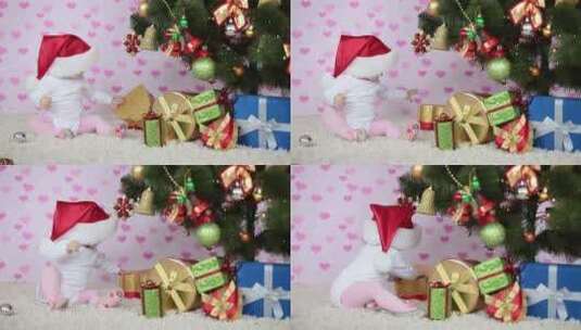 孩子坐在圣诞树旁玩圣诞礼盒高清在线视频素材下载