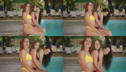 慢动作三个穿着比基尼的女孩在夏日坐在游泳高清在线视频素材下载