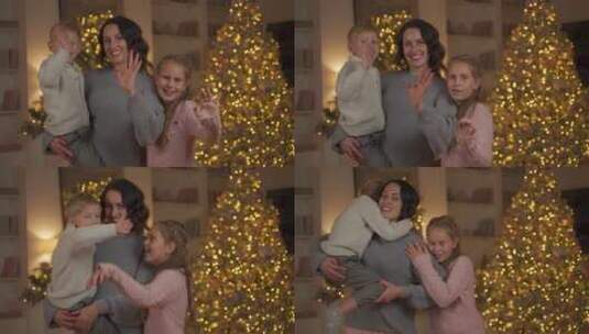 母亲带着孩子在圣诞树旁合影高清在线视频素材下载